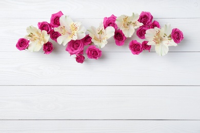 Photo of Fresh flowers on wooden background, top view with space for text