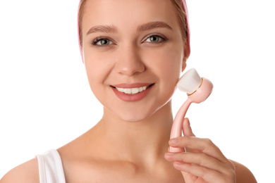 Photo of Young woman washing face with cleansing brush on white background. Cosmetic product