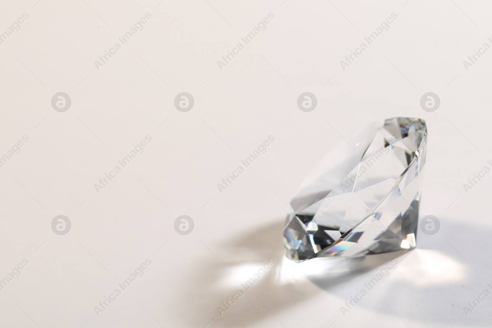 Photo of Beautiful dazzling diamond on white background. Space for text