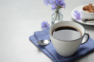 Photo of Cup of delicious chicory drink on light grey table, space for text