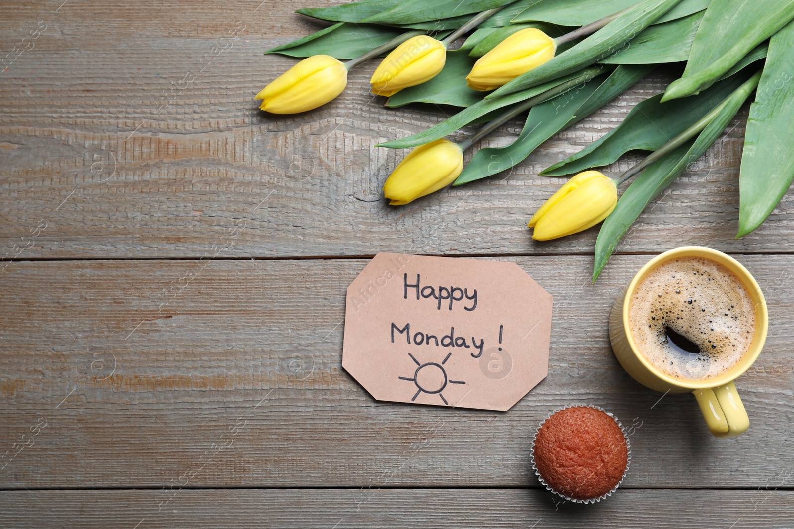 Photo of Happy Monday message, aromatic coffee, cupcake and tulips on wooden table, flat lay