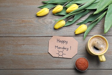 Happy Monday message, aromatic coffee, cupcake and tulips on wooden table, flat lay