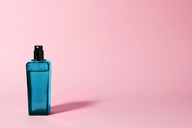 Photo of Bottle of perfume on color background