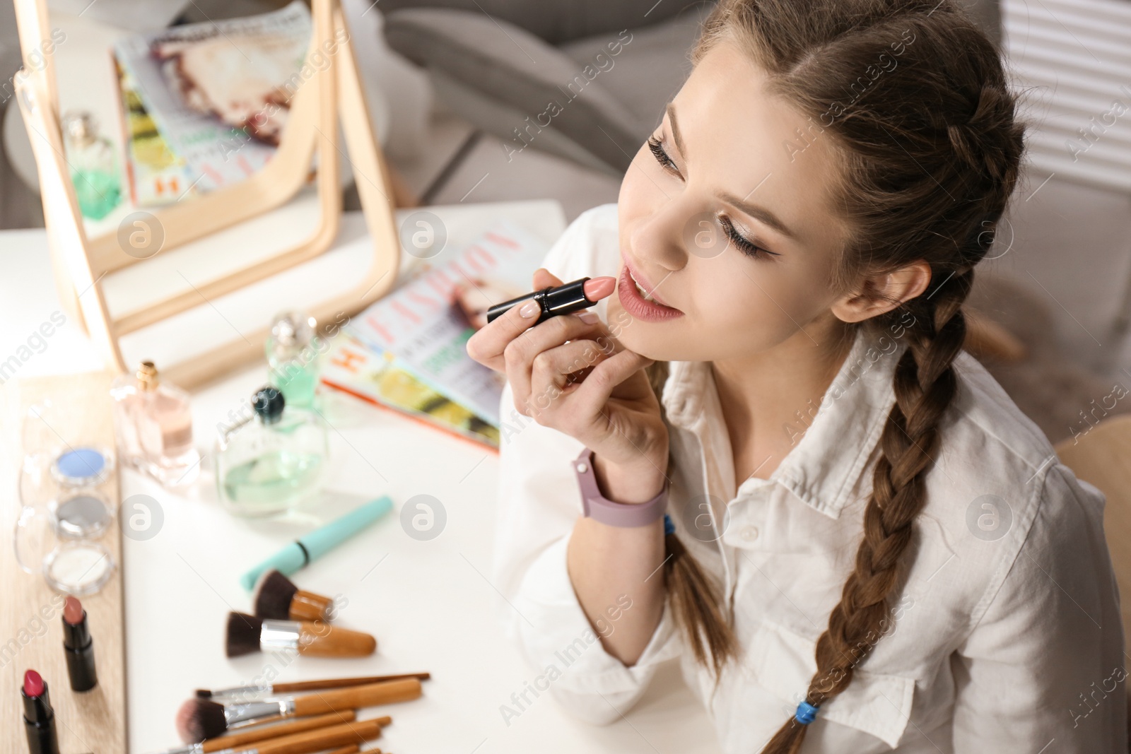 Photo of Portrait of beautiful woman applying makeup indoors