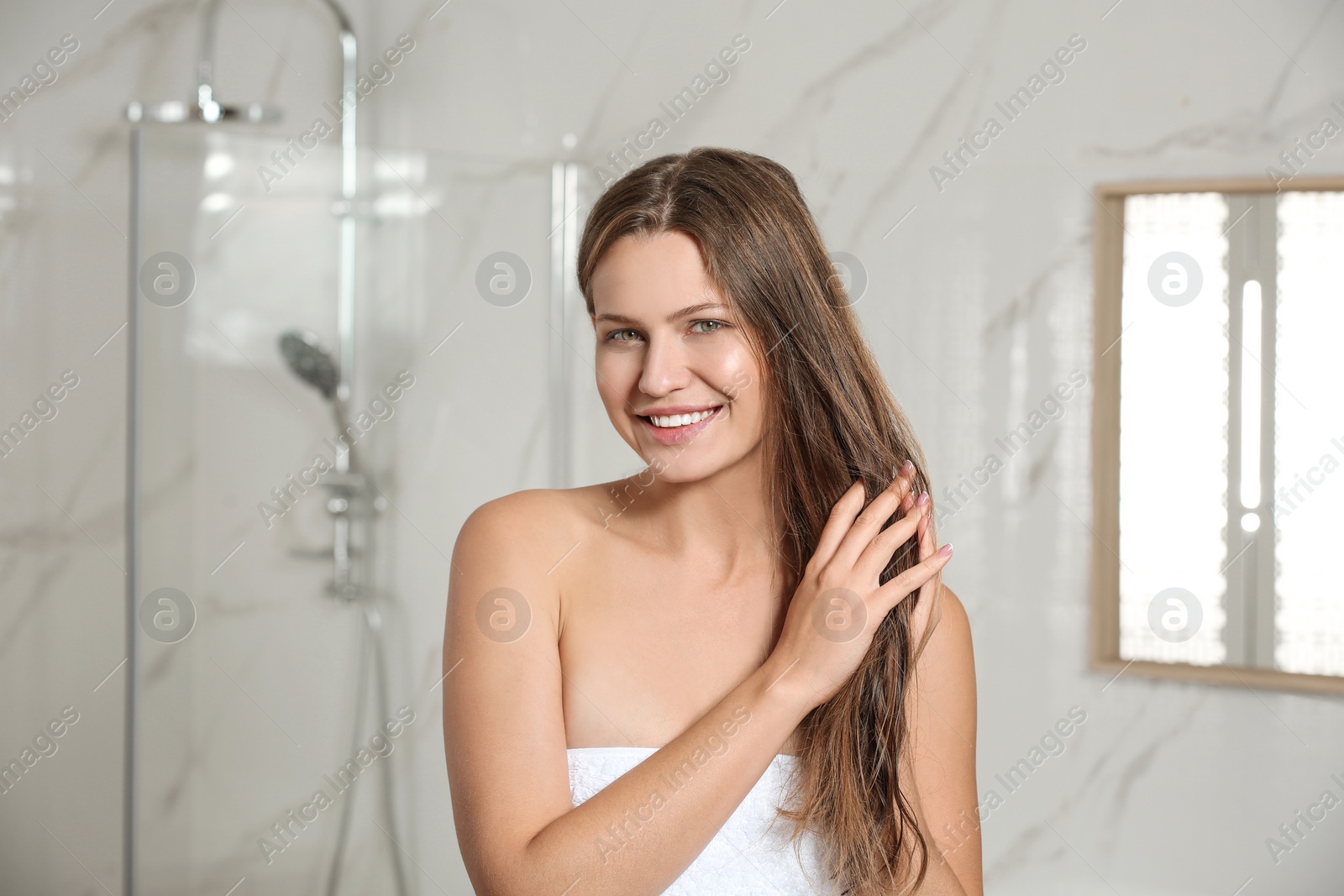 Image of Beautiful young woman with wet hair in bathroom