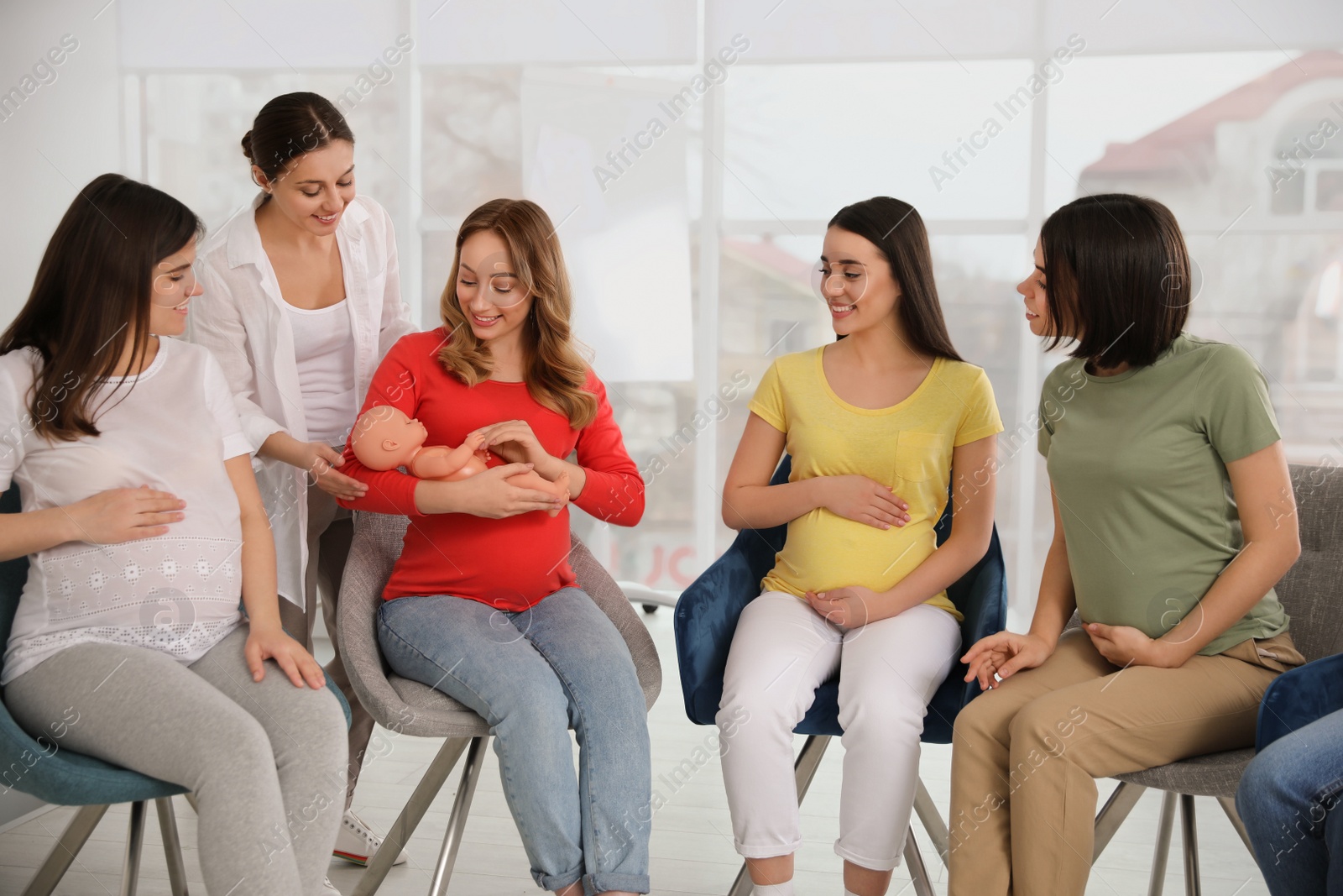 Photo of Group of pregnant women with midwife at courses for expectant mothers indoors