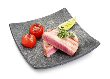 Photo of Pieces of delicious tuna with microgreens, lime and tomatoes on white background