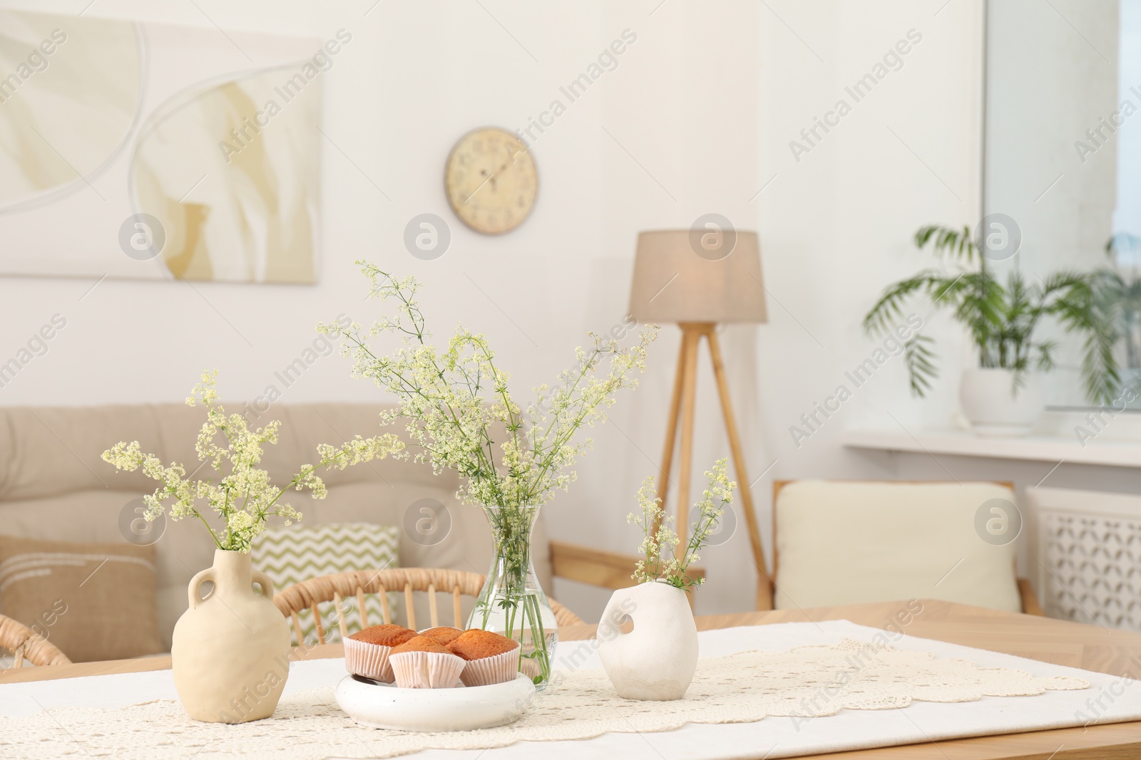 Photo of Fresh pastries and beautiful flowers on table in stylish dining room