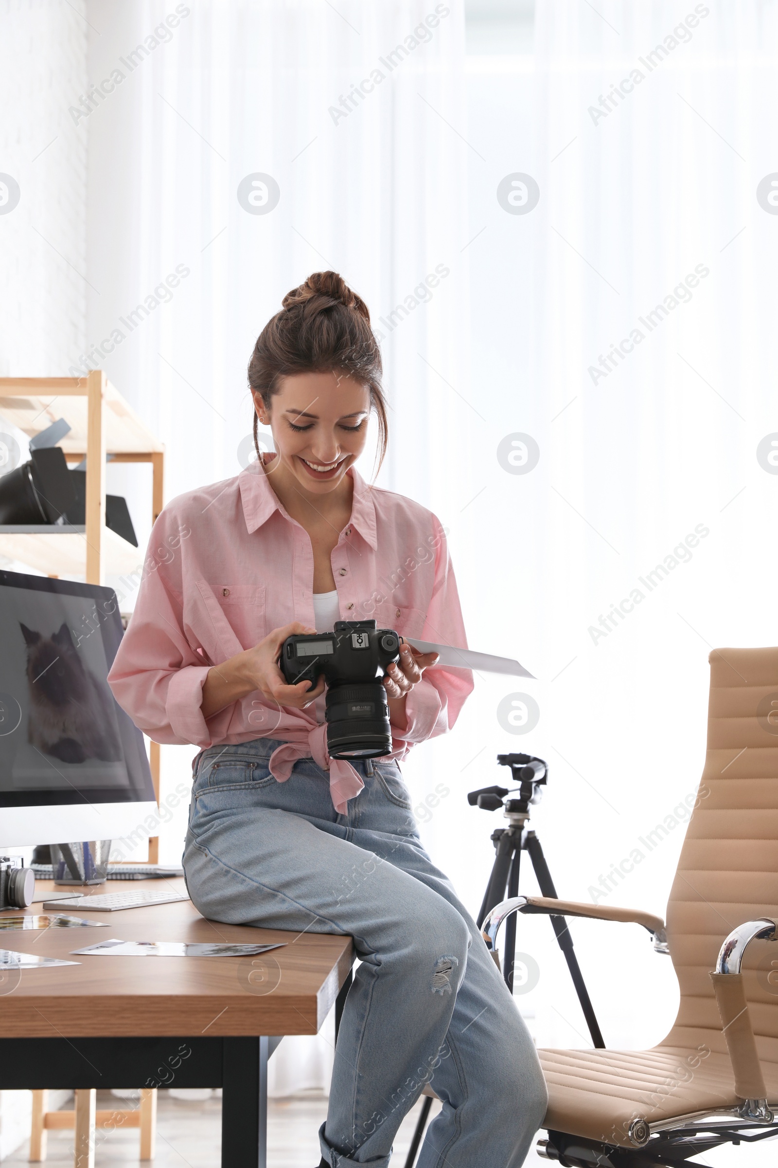 Photo of Professional photographer with camera working in light modern office