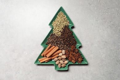 Different spices and nuts on light gray textured table, top view