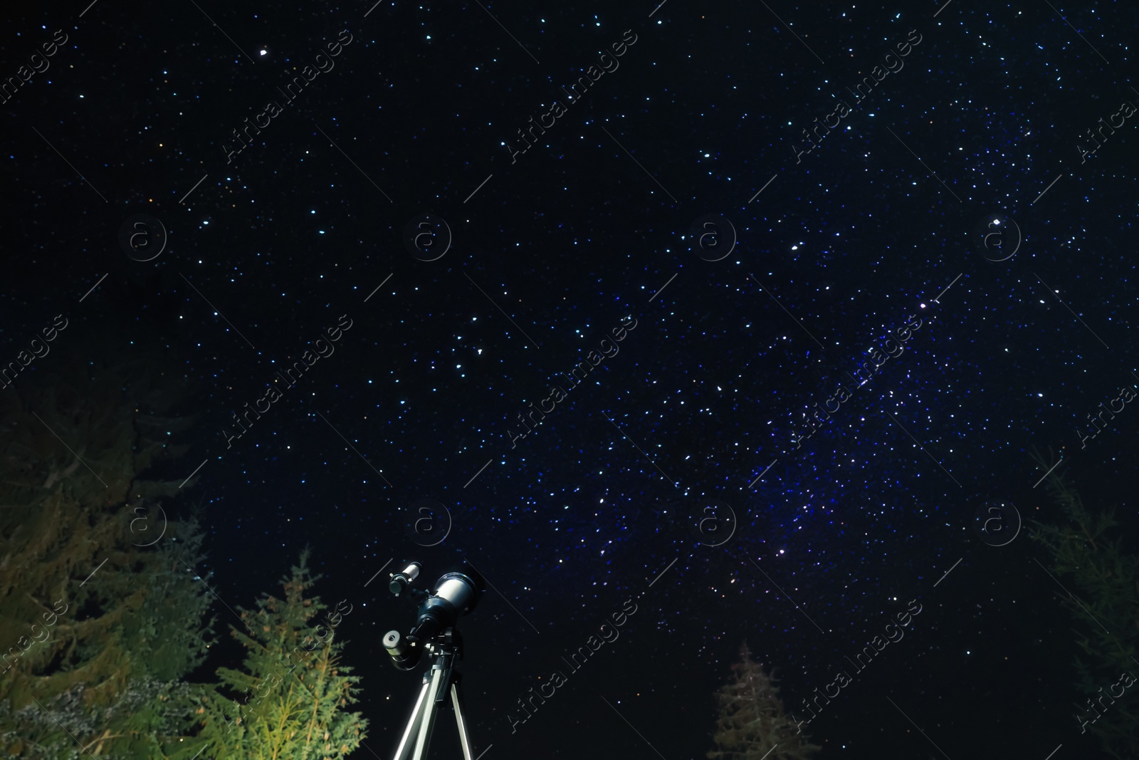 Photo of Modern telescope at night outdoors, low angle view. Learning astronomy