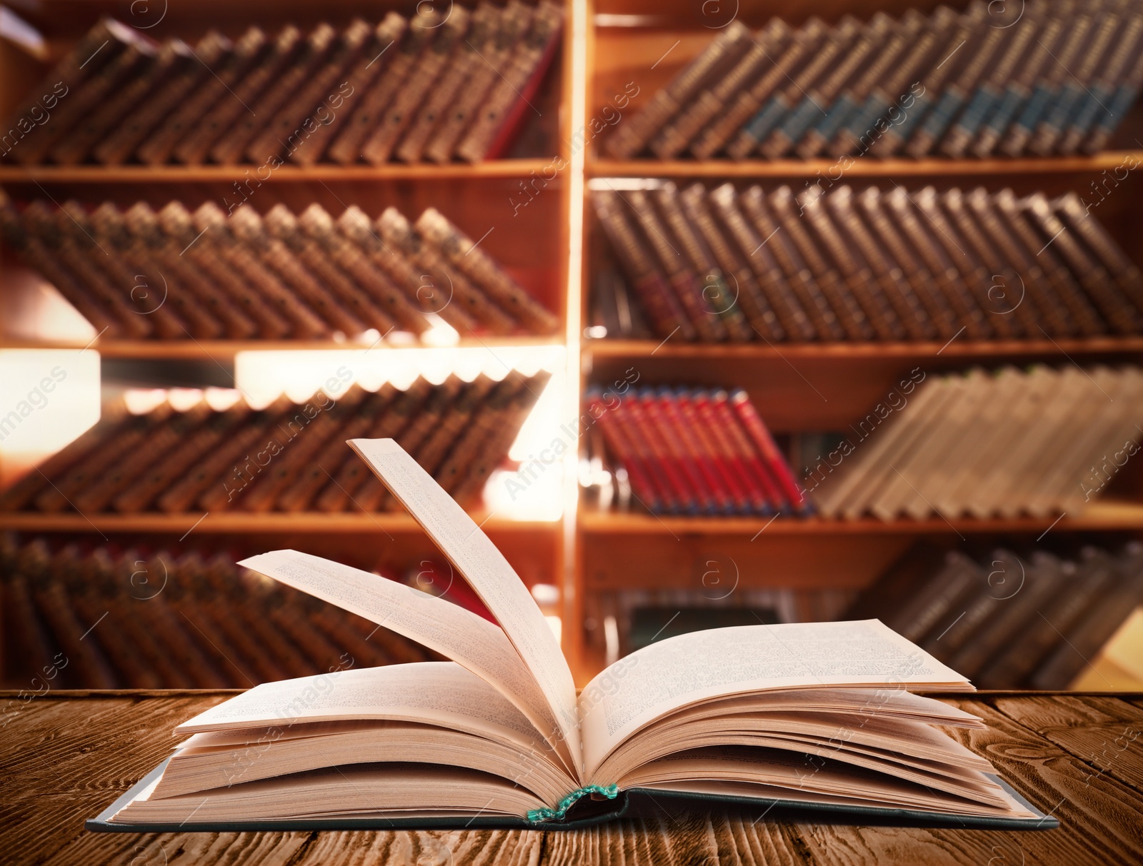 Image of Open book on wooden table in library