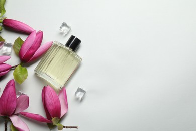 Photo of Beautiful pink magnolia flowers, bottle of perfume and ice cubes on light grey background, flat lay. Space for text