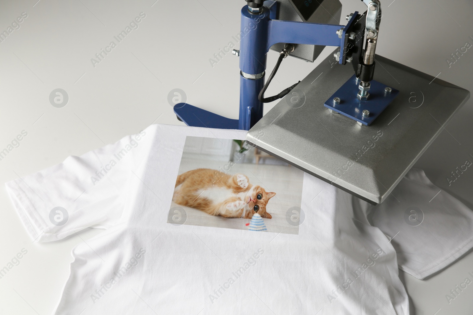 Image of Custom t-shirt. Using heat press to print photo of cute ginger cat