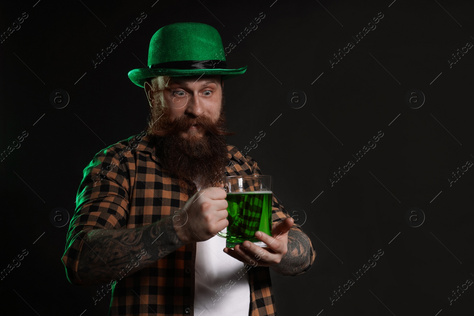 Photo of Bearded man with green beer on black background, space for text. St. Patrick's Day celebration