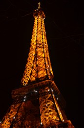 Paris, France - December 10, 2022: Beautiful illuminated Eiffel Tower at night, low angle view