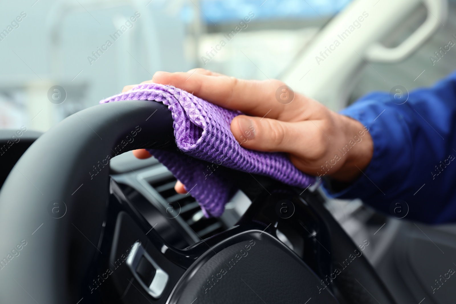 Photo of Car wash worker cleaning automobile interior, closeup