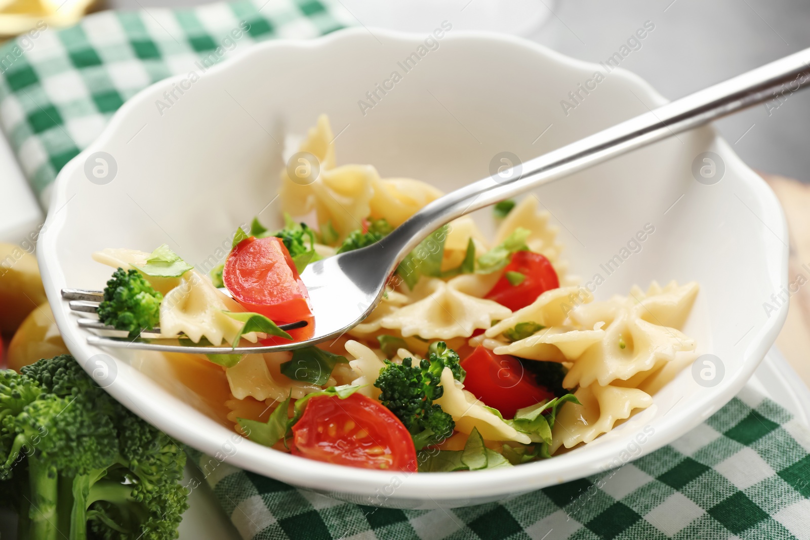 Photo of Tasty pasta salad with vegetables on table