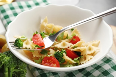 Tasty pasta salad with vegetables on table