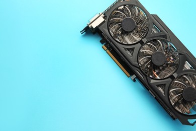 Photo of One graphics card on light blue background, top view. Space for text