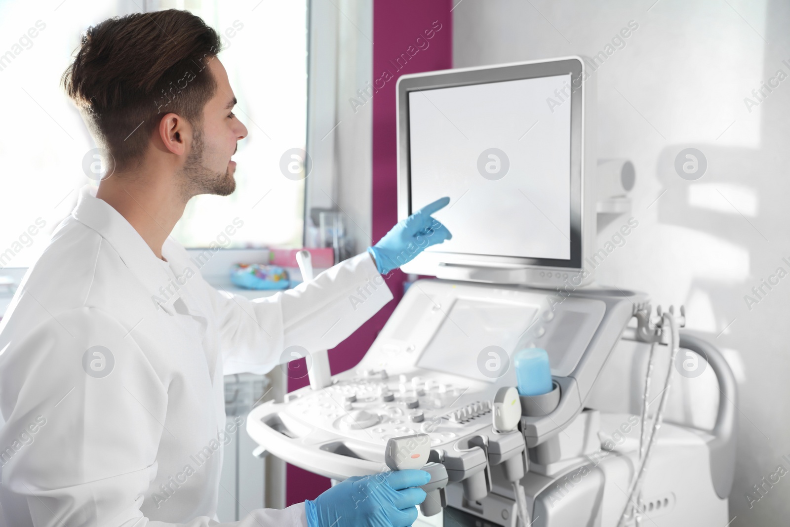 Photo of Sonographer using modern ultrasound machine in clinic