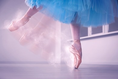 Image of Perfection in ballet. Woman dancing in pointe shoes in studio, closeup. Motion effect with smoke