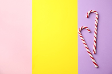 Photo of Flat lay composition with candy canes on color background. Space for text