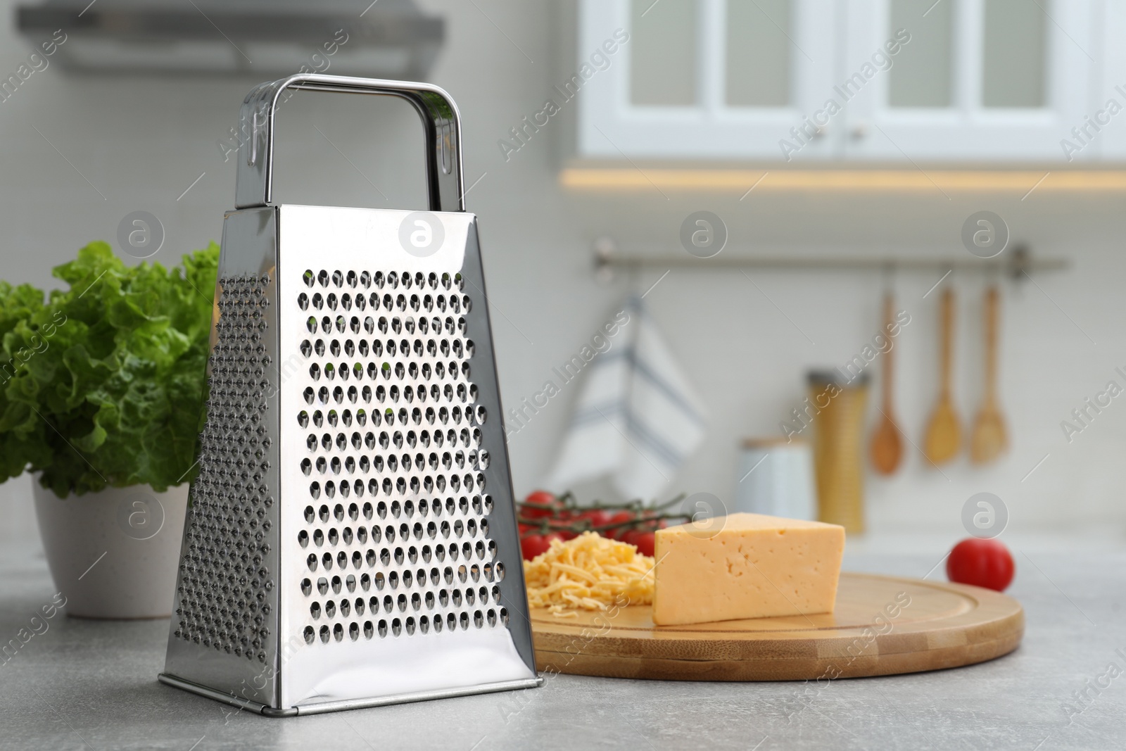 Photo of Grater and cheese on table in kitchen. Space for text