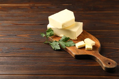 Photo of Tasty butter and parsley on wooden table. Space for text