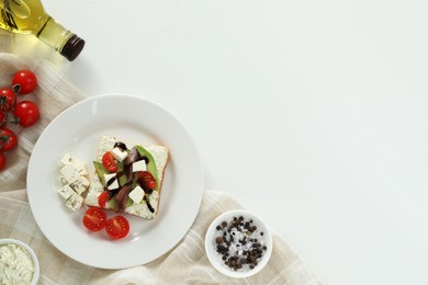 Delicious sandwich with anchovies, cheese and tomato on white table, flat lay. Space for text