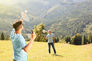 Photo of Friends playing badminton in mountains on sunny day