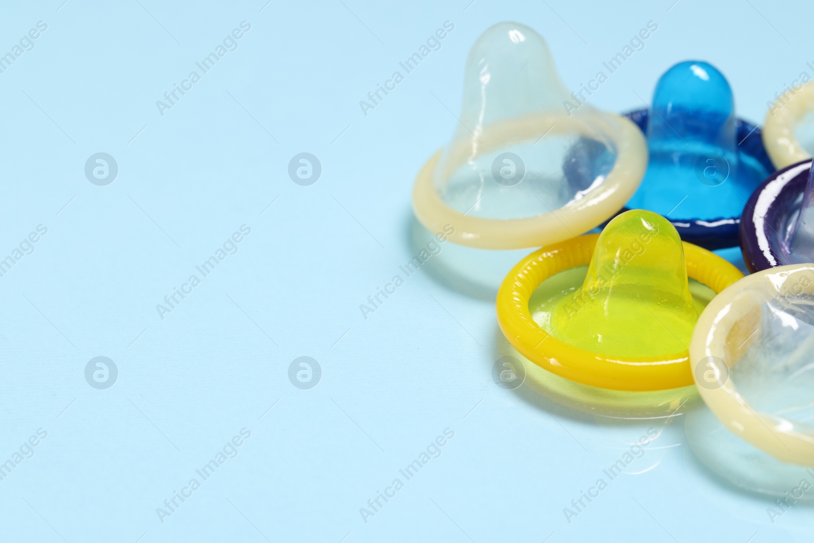 Photo of Condoms on light blue background, space for text. Safe sex