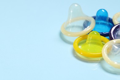 Photo of Condoms on light blue background, space for text. Safe sex