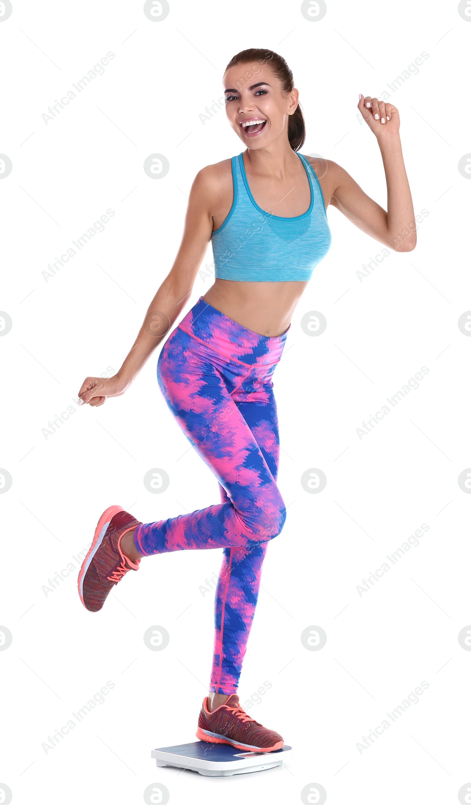 Photo of Happy young woman measuring her weight using scales on white background. Weight loss motivation