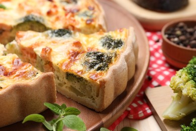 Photo of Delicious homemade quiche and ingredients on table, closeup