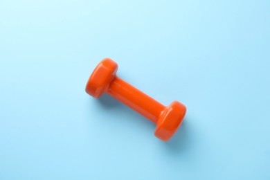 Photo of Stylish dumbbell on light blue background, top view