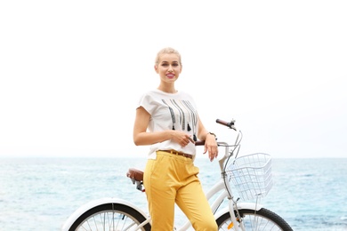 Photo of Beautiful woman in casual outfit with bicycle on sea coast