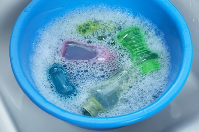 Photo of Light blue basin with baby bottles, above view