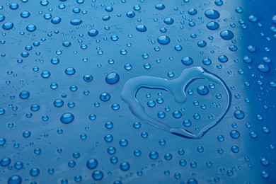 Photo of Heart shape of water and drops on blue background