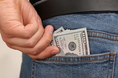 Man putting money into pocket of jeans, closeup