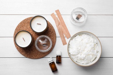 Photo of Flat lay composition with homemade candles and ingredients on white wooden background