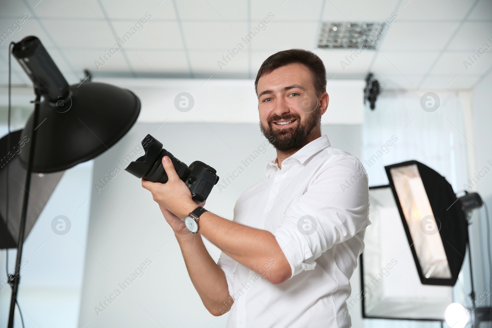 Photo of Professional photographer with camera in photo studio