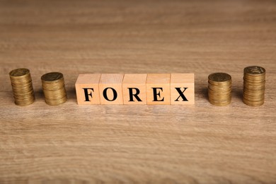 Photo of Word Forex made with cubes and stacked coins on wooden table, closeup