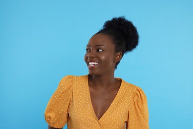 Portrait of beautiful young woman on light blue background