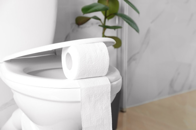 New paper roll on toilet seat in bathroom