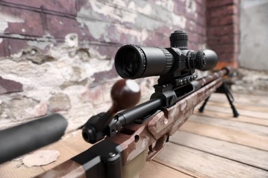 Photo of Closeup view of modern powerful sniper rifle with telescopic sight outdoors