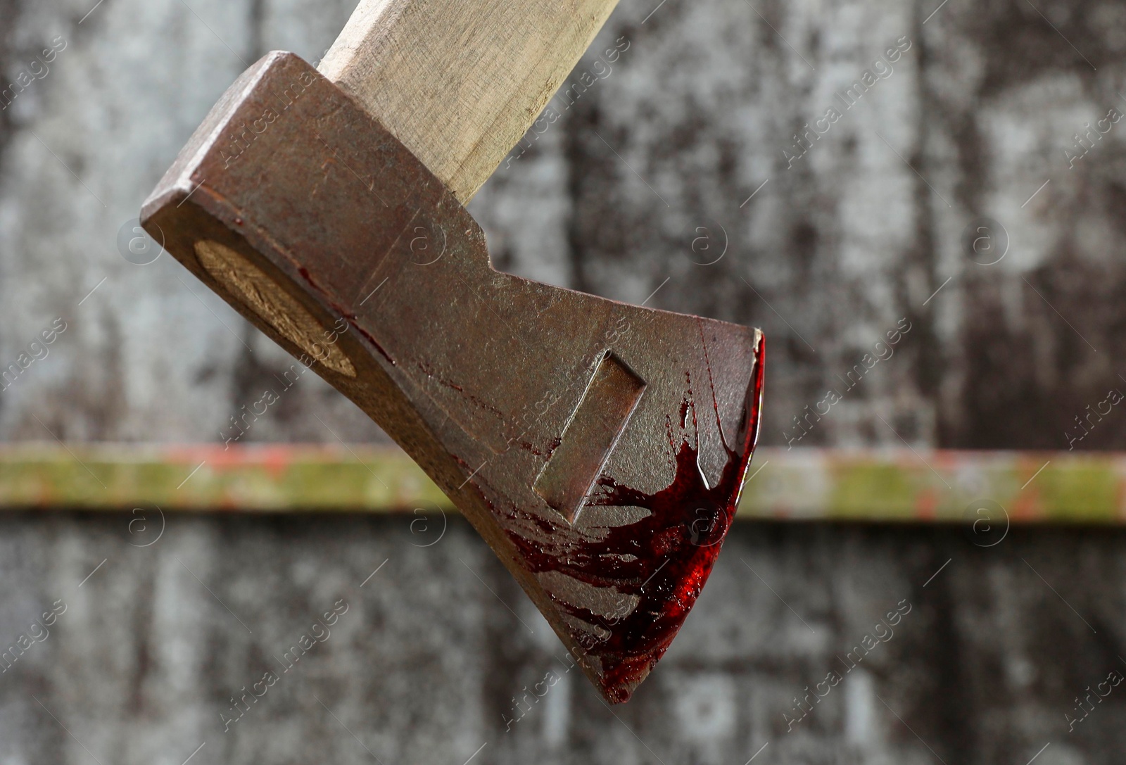 Photo of Axe with blood against blurred background, closeup