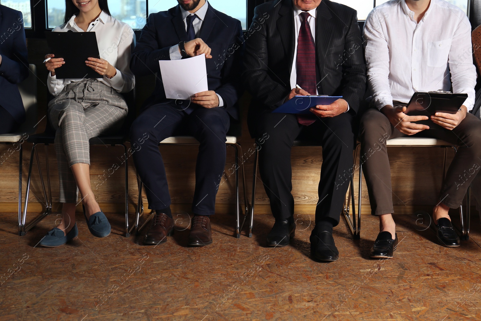 Photo of People waiting for job interview in office hall, closeup