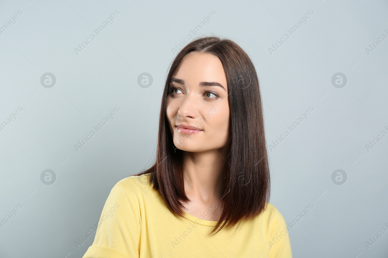 Photo of Portrait of pretty young woman with gorgeous chestnut hair on light grey background