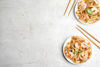 Tasty buckwheat noodles with shrimps served on light table, flat lay. Space for text